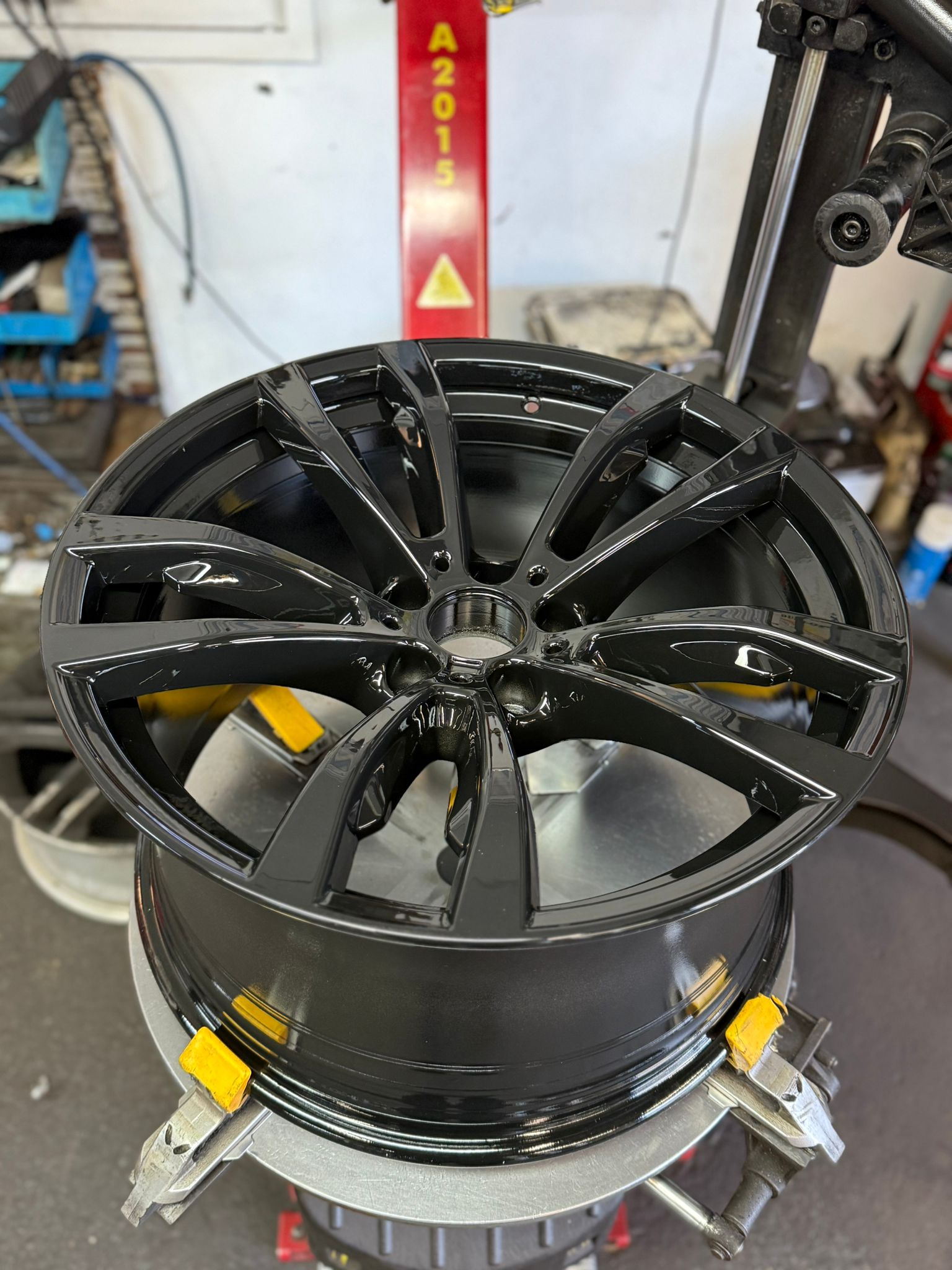 After — Flaking, kerbed gloss-black wheel stripped right back, repaired and powder-coated to a deep gloss finish. — Burnley